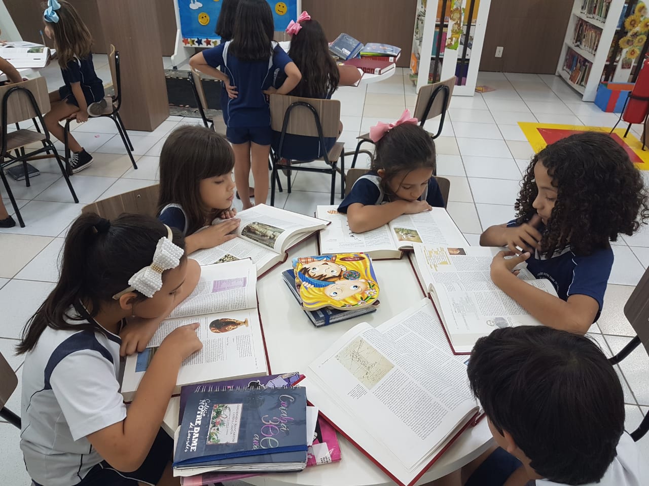 Aula interativa com manuseio de enciclopédias